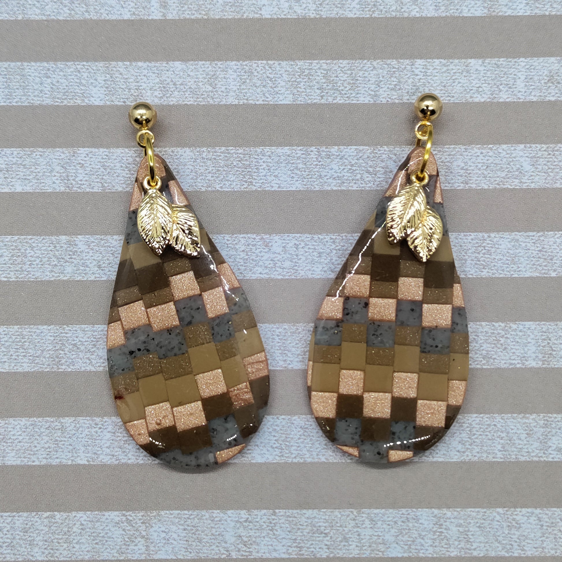 Teardrop-shaped earrings with checkered pattern and gold leaf accents