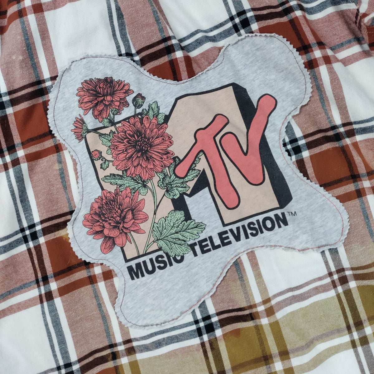 MTV Music Television patch on a plaid fabric background