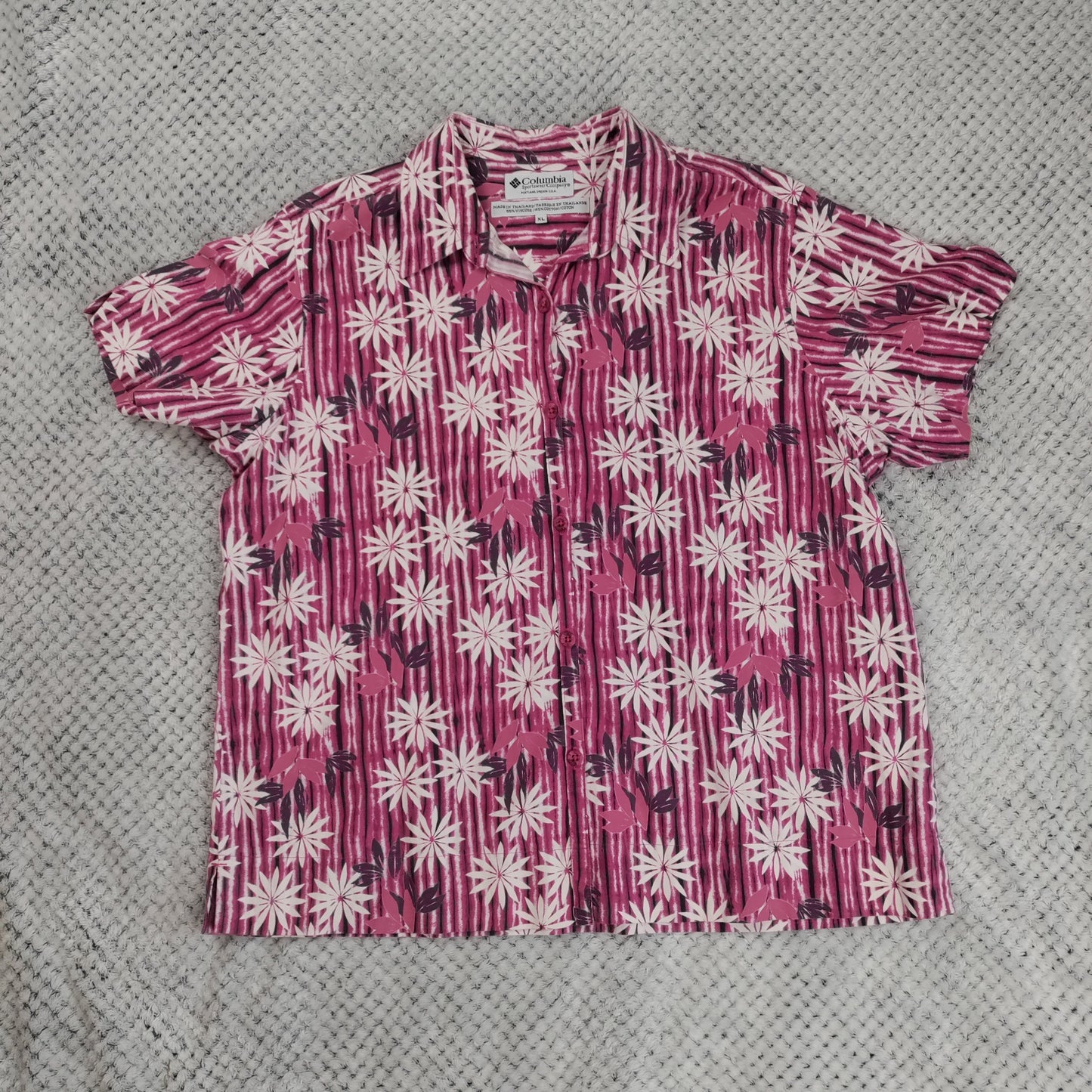 Short-sleeve shirt with pink and white floral pattern on a gray textured background