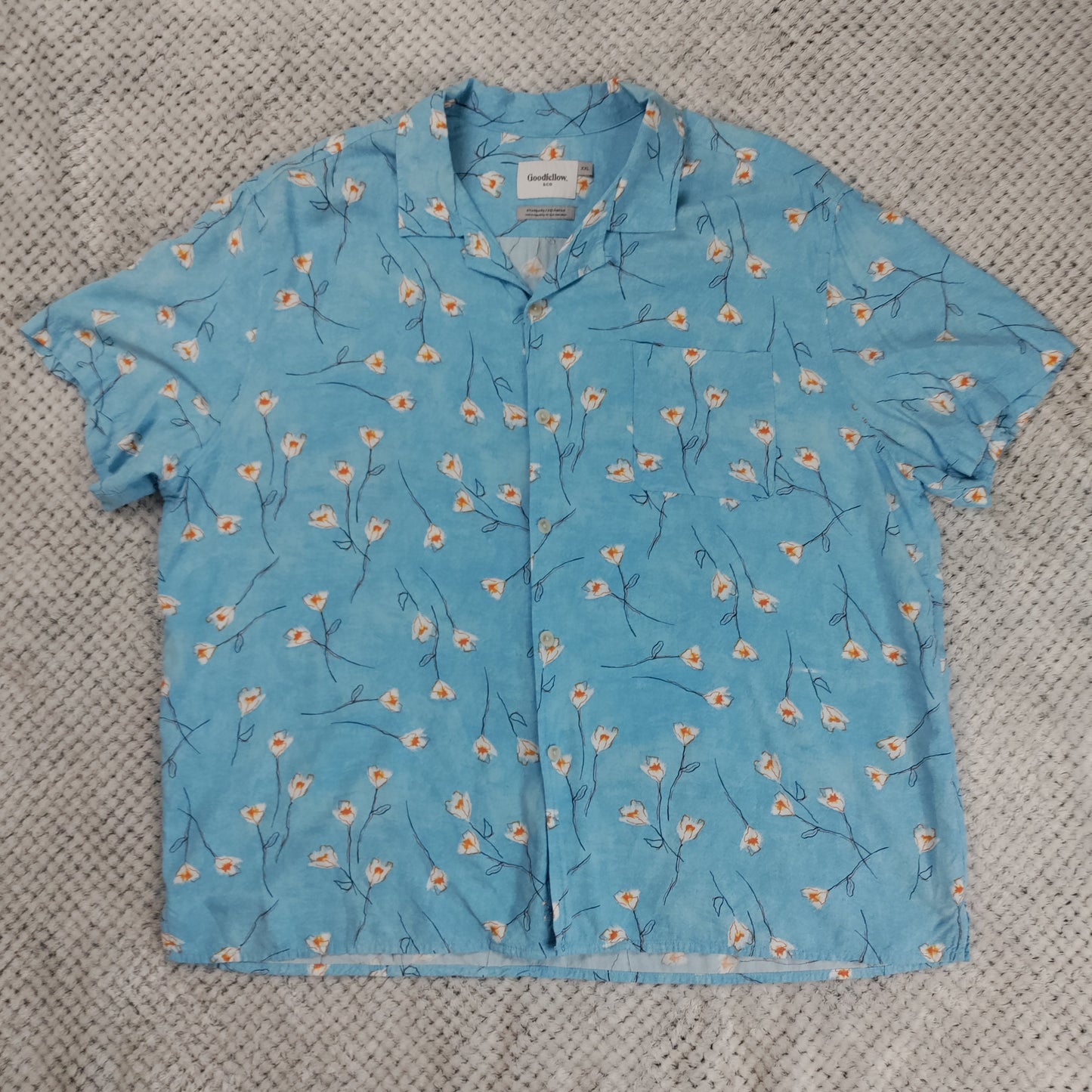 Blue floral-patterned shirt on a textured gray surface