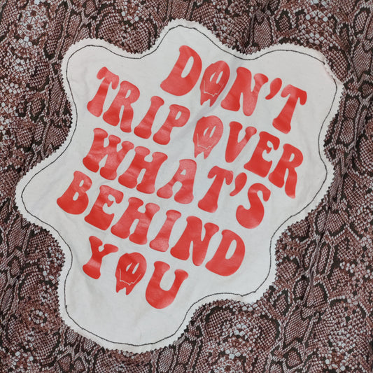 Text patch on fabric with red lettering and white border