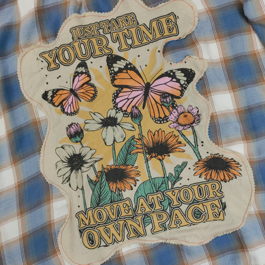 Decorative patch with butterflies and flowers on a plaid fabric background