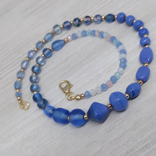 Blue beaded necklace on a light gray surface
