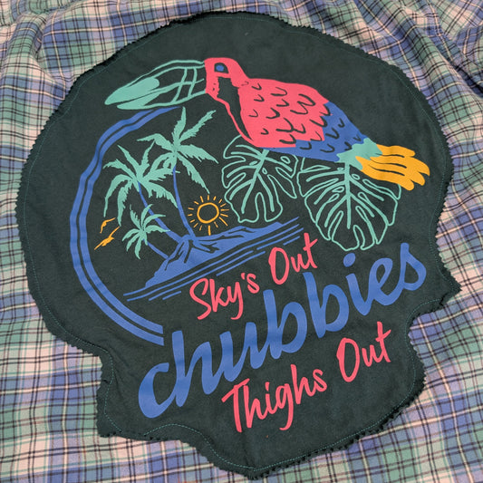 Embroidered patch with tropical design and text on a plaid fabric background