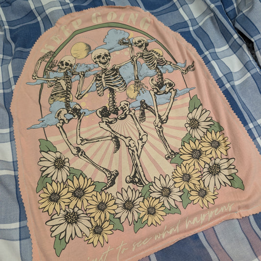 Skeletal design with flowers on a pink patch over a blue plaid fabric background