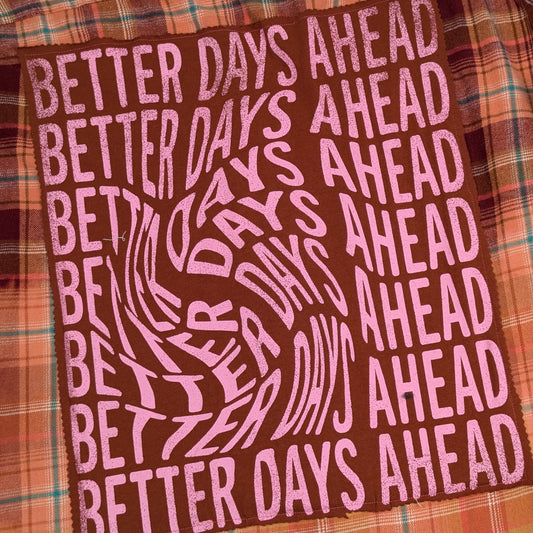 Text 'Better Days Ahead' on a plaid fabric background