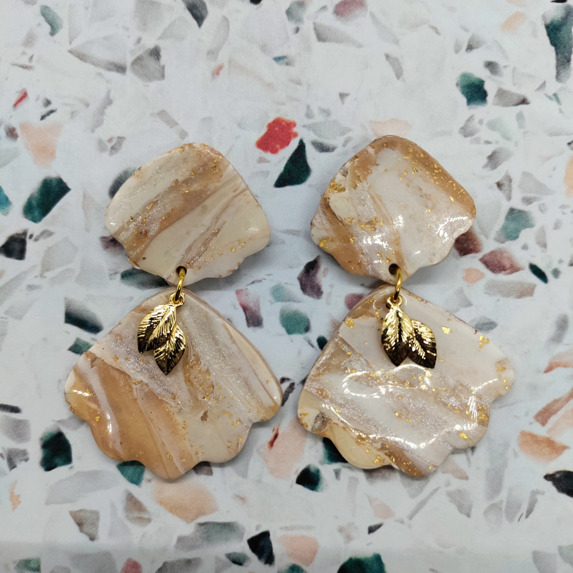 Pair of beige and gold earrings.