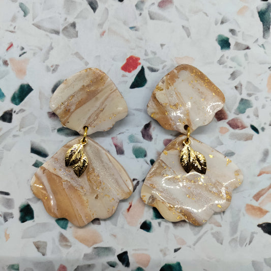 Pair of beige and gold earrings.