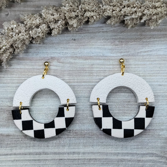 Pair of earrings with checkered design on a textured surface