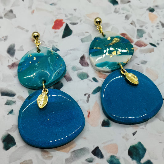 Blue and gold earrings on a terrazzo background