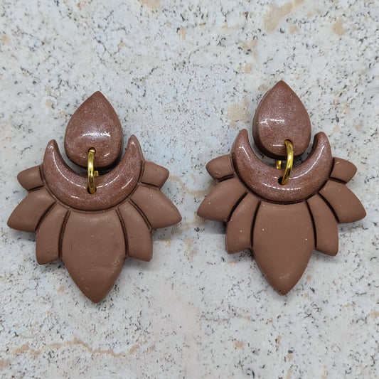 Pair of brown earrings on a light gray surface