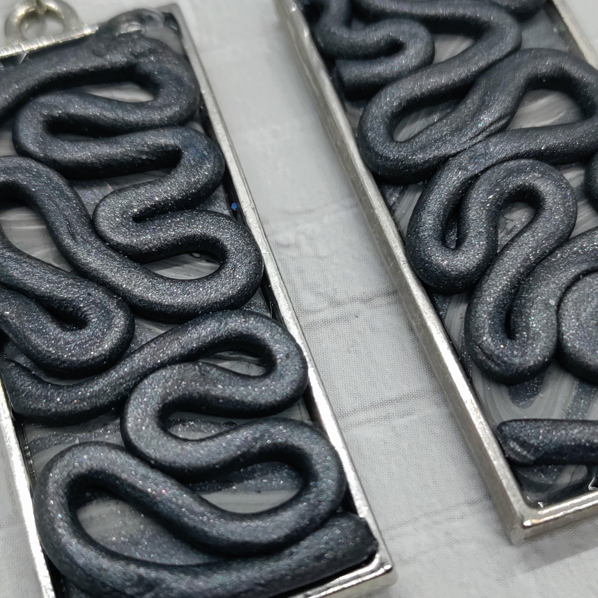 Close-up of a metal stamp with wavy pattern on a white background