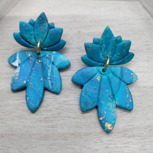 Pair of blue flower-shaped earrings on a light gray surface