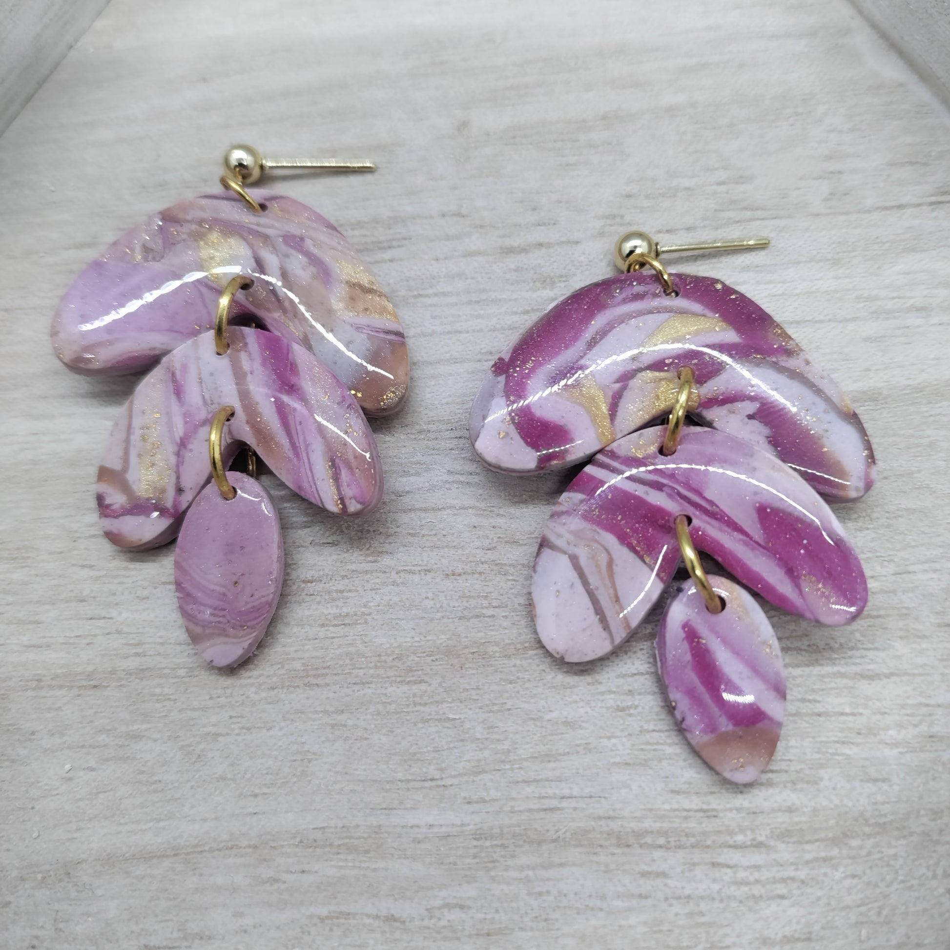 Pair of pink marbled earrings on a light gray background
