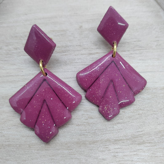 Pair of pink earrings with gold accents on a light gray background