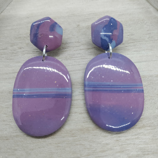 Purple and blue striped earrings on a light gray surface