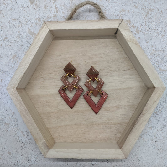 Hexagonal wooden tray with red earrings on a textured surface