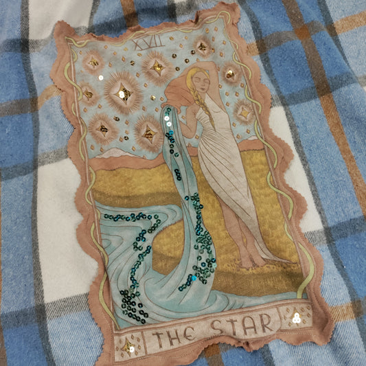 Decorative card with 'The Star' tarot card design on a plaid fabric background