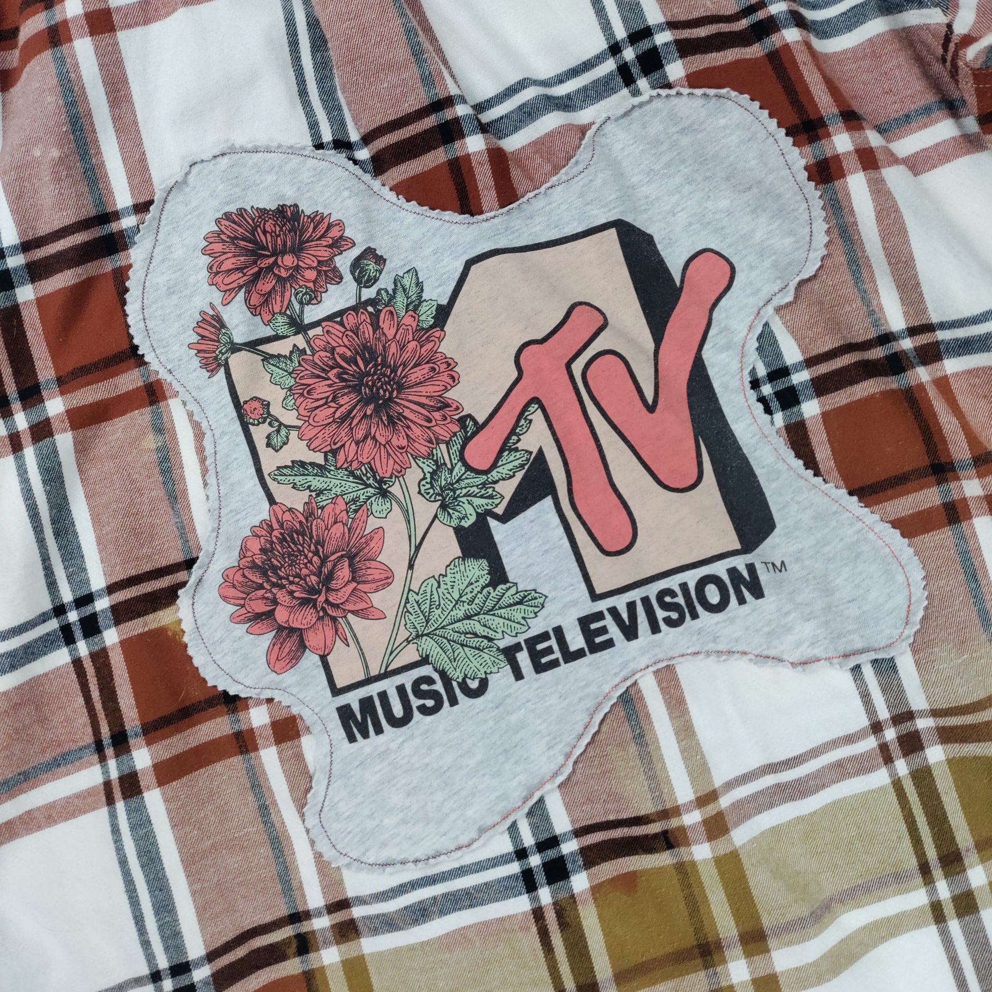 MTV Music Television patch on a plaid fabric background