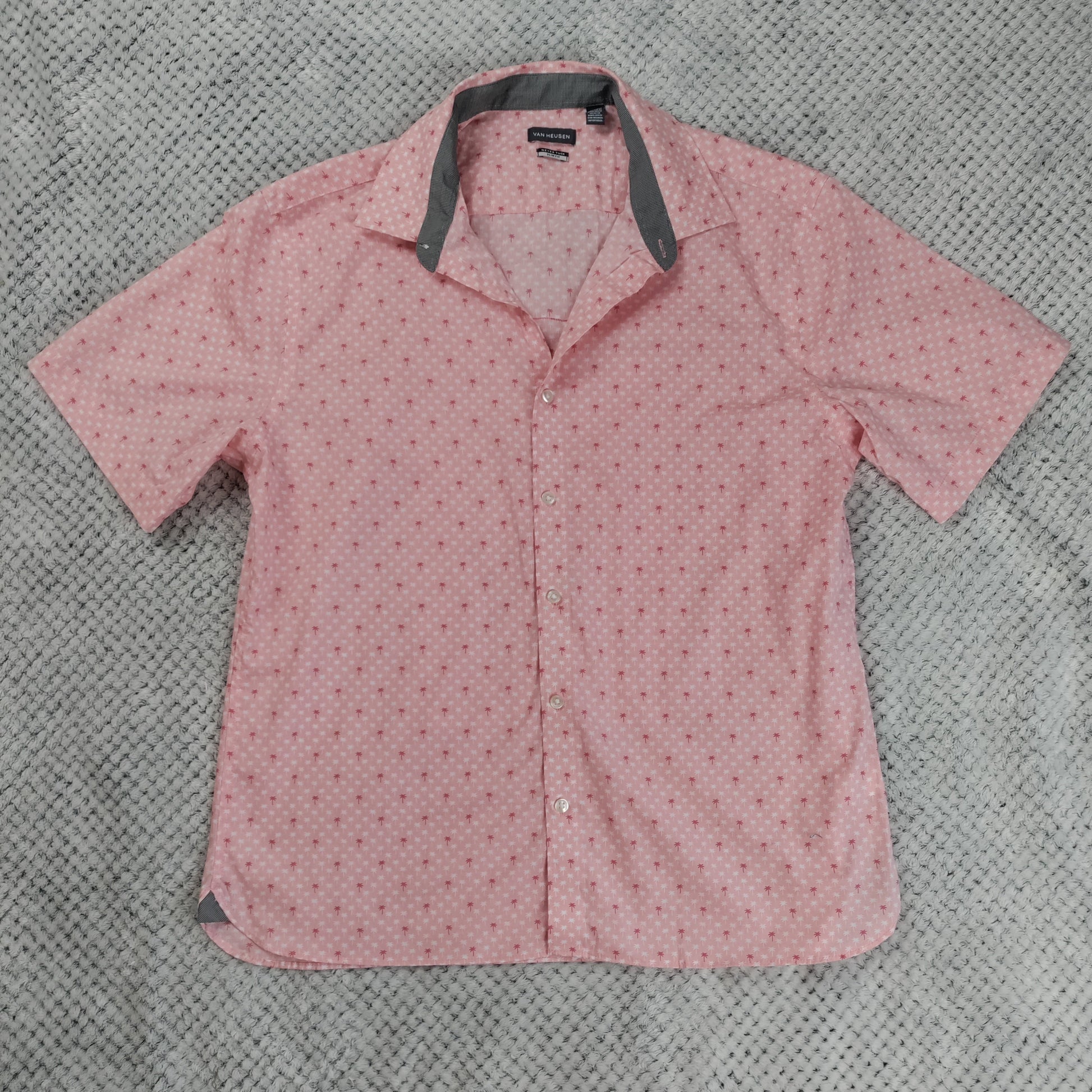 Pink short-sleeve shirt with a collar on a gray textured background