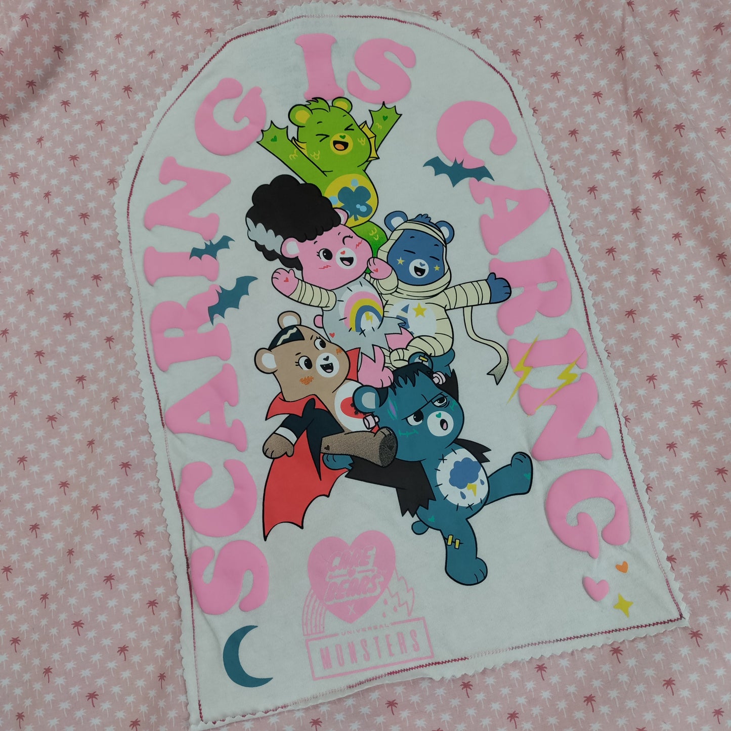 Patch with cartoon characters and text 'Scaring is Caring' on a pink polka dot background