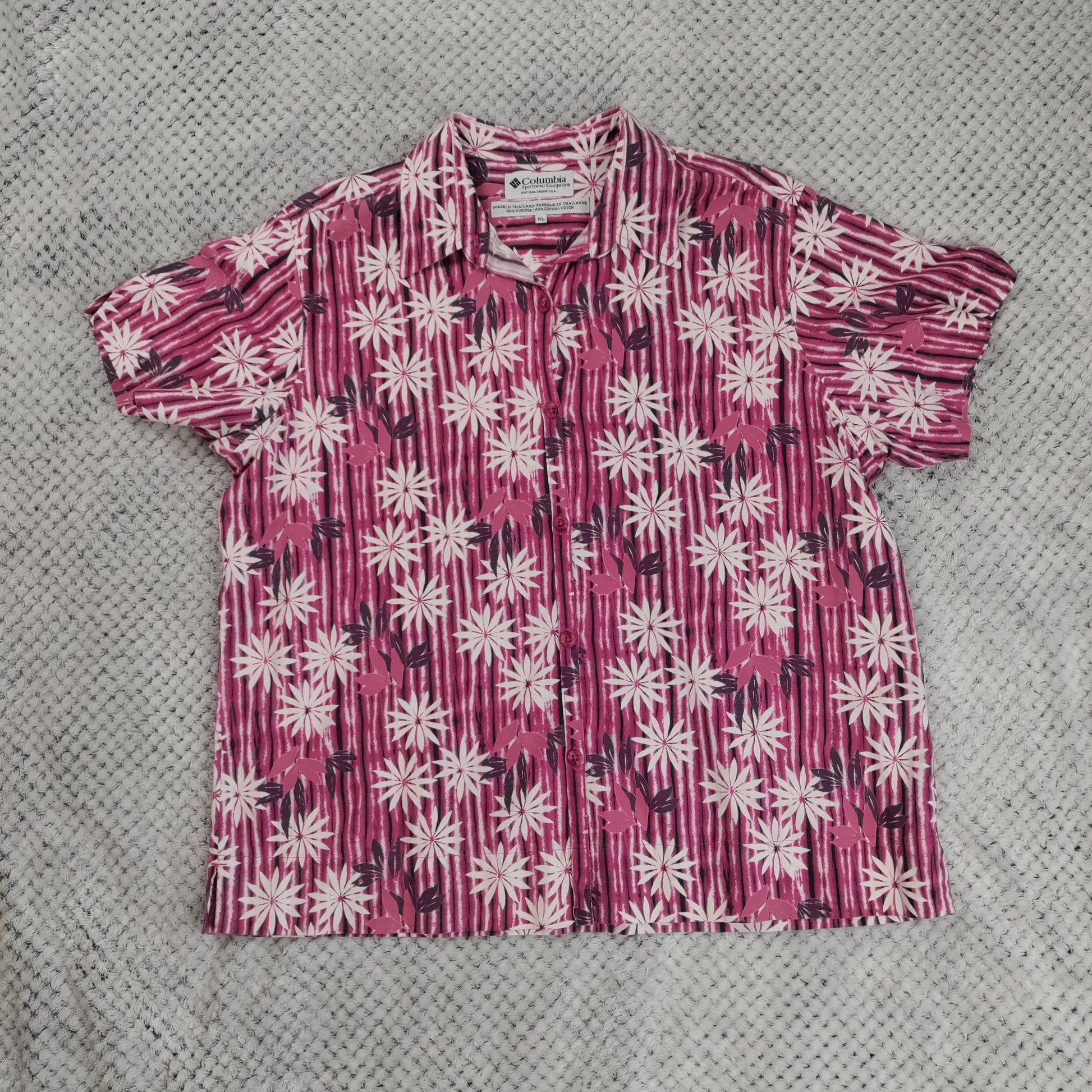 Short-sleeve shirt with pink and white floral pattern on a gray textured background