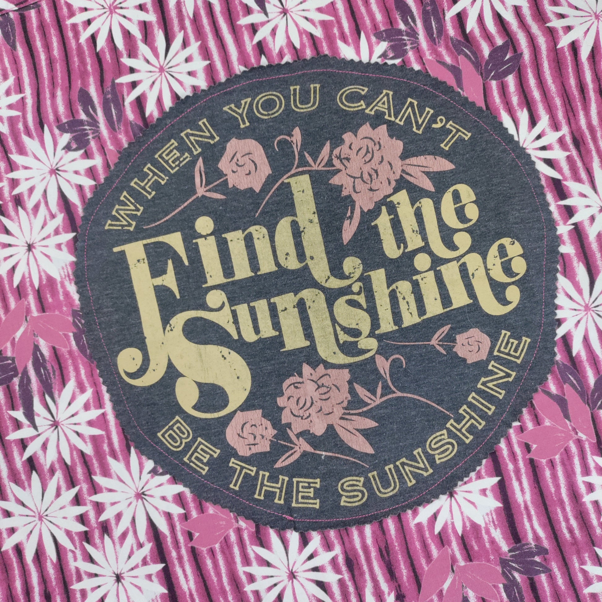 Floral patterned fabric with a motivational quote patch.