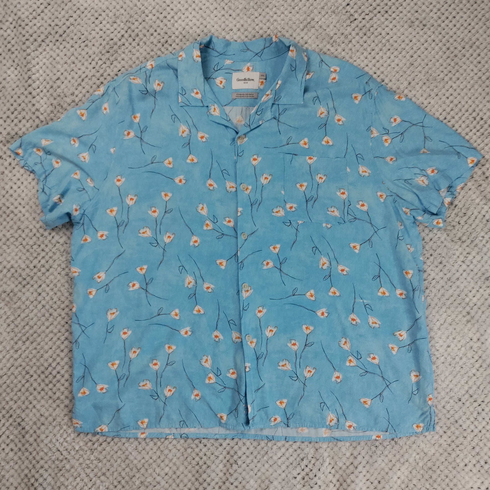 Blue floral-patterned shirt on a textured gray surface