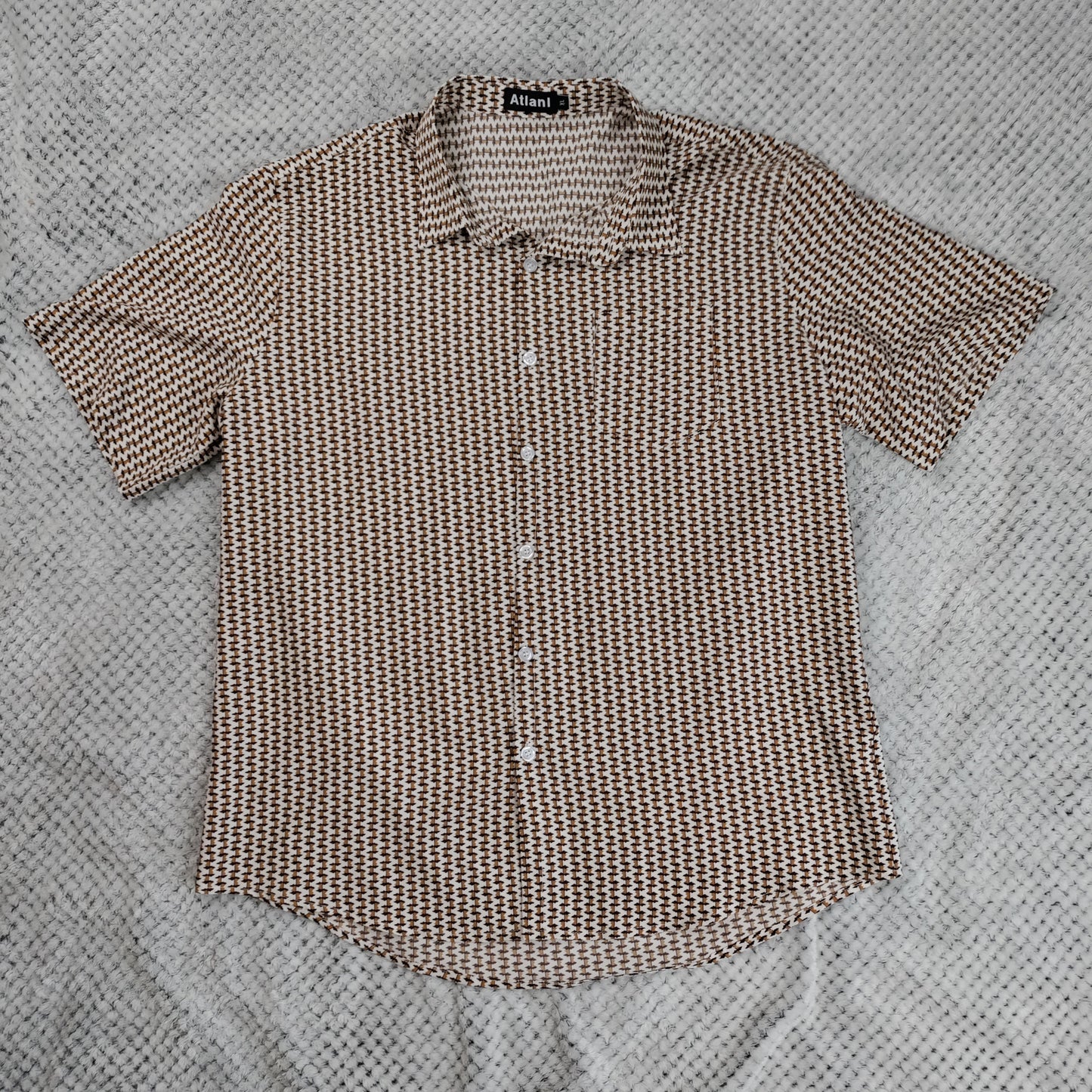 Brown patterned shirt on a textured gray surface