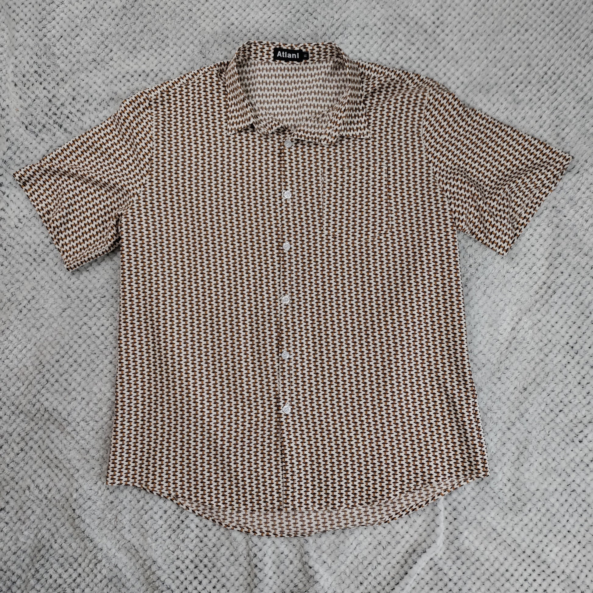 Brown patterned shirt on a textured gray surface