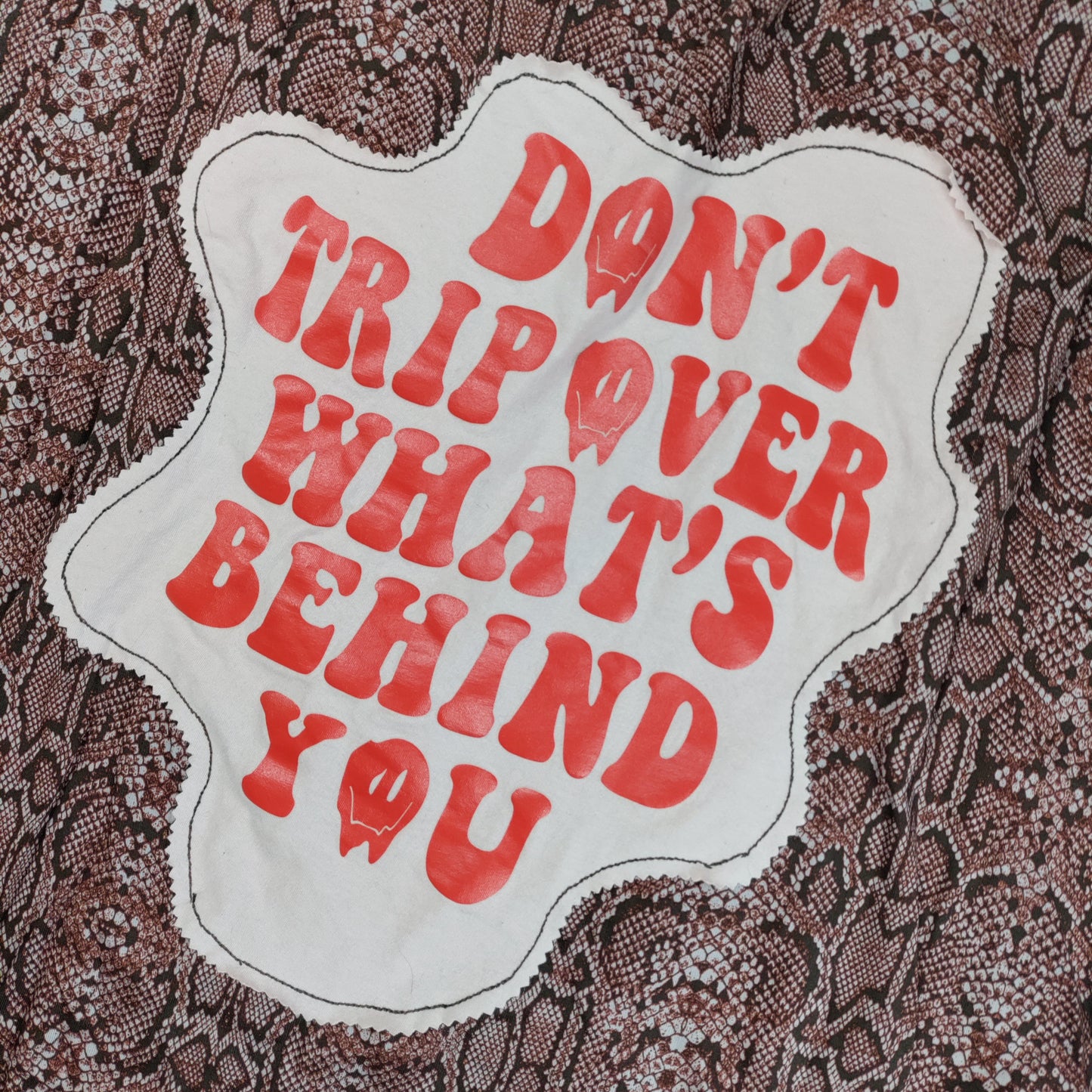 Text patch on fabric with red lettering and white border