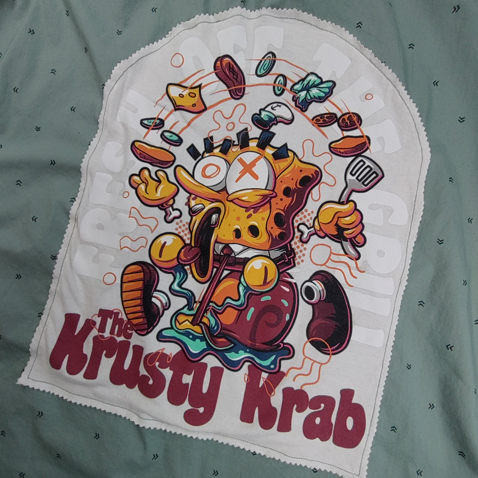 Embroidered patch of a cartoon character from 'The Krusty Krab' on a green fabric background.
