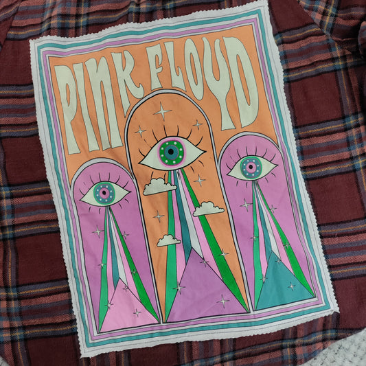 Pink Floyd poster with eye design on a plaid fabric background