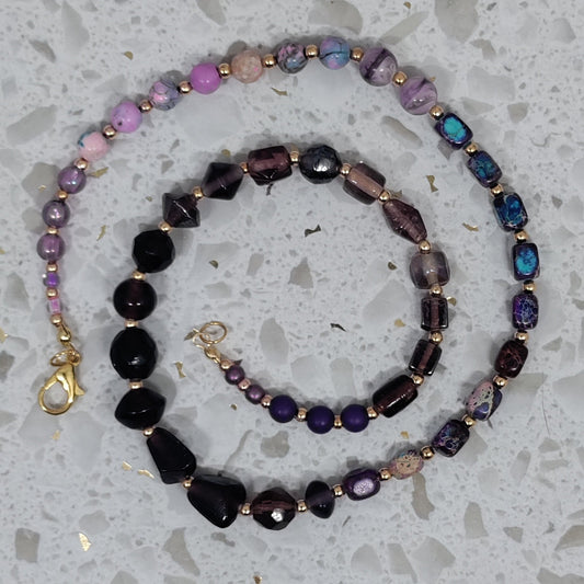 Set of beaded necklaces on a speckled gray surface