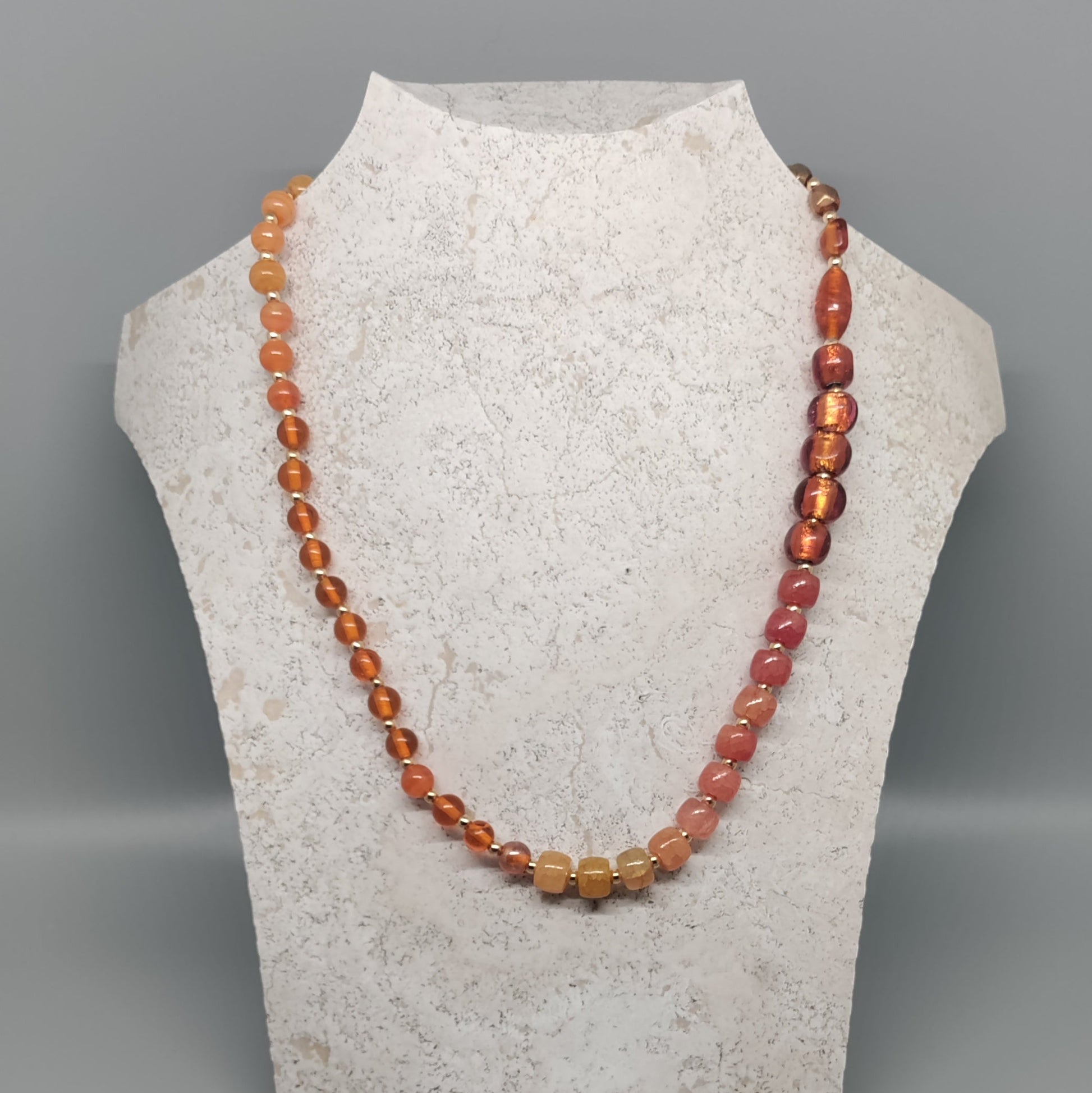 Necklace on a mannequin bust against a gray background