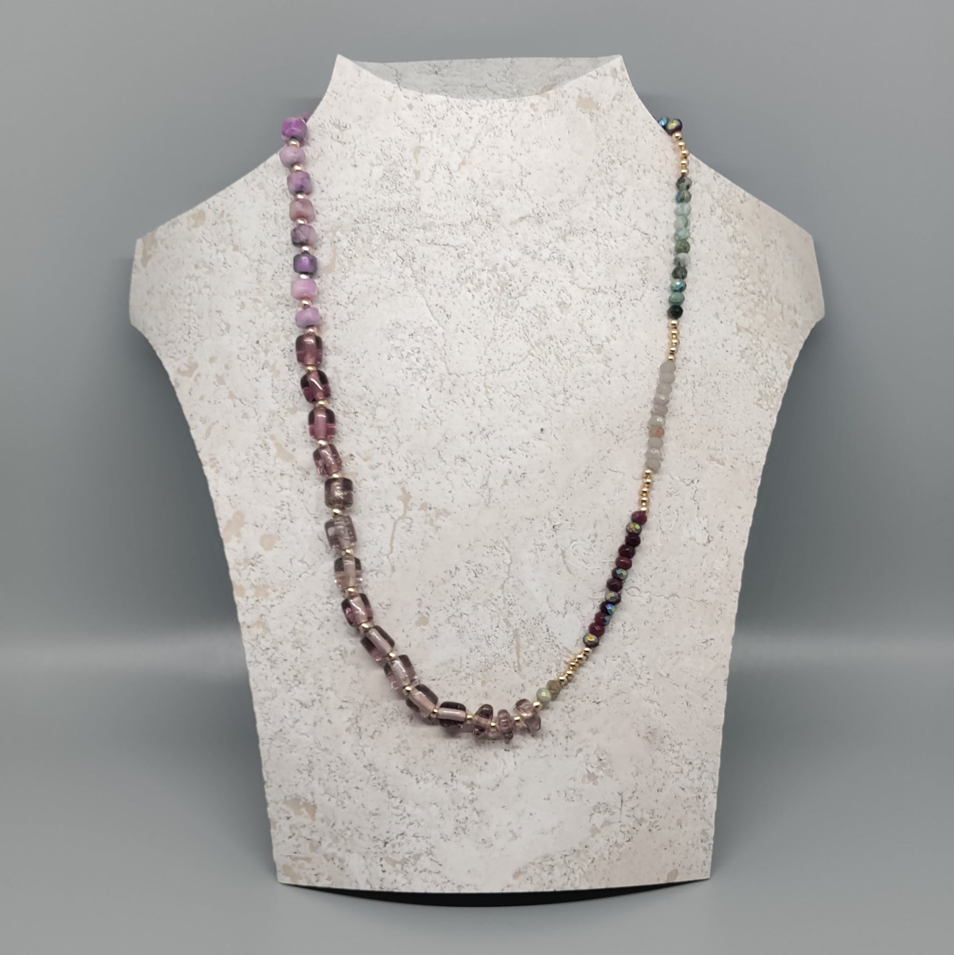 Necklace displayed on a mannequin bust against a gray background