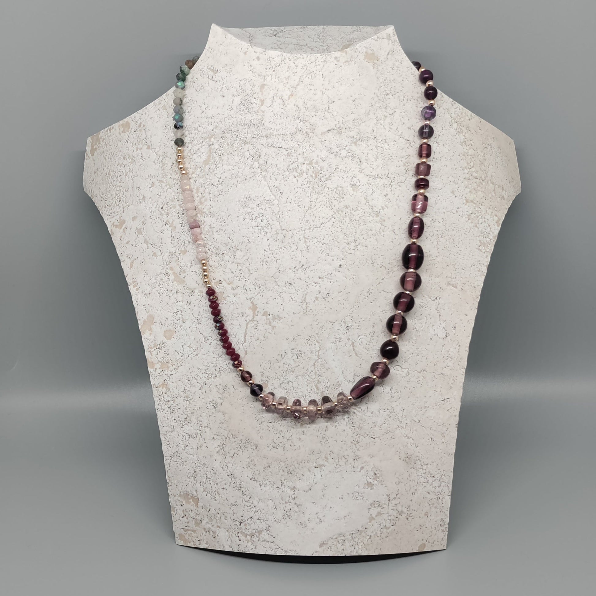Necklace displayed on a mannequin bust against a gray background