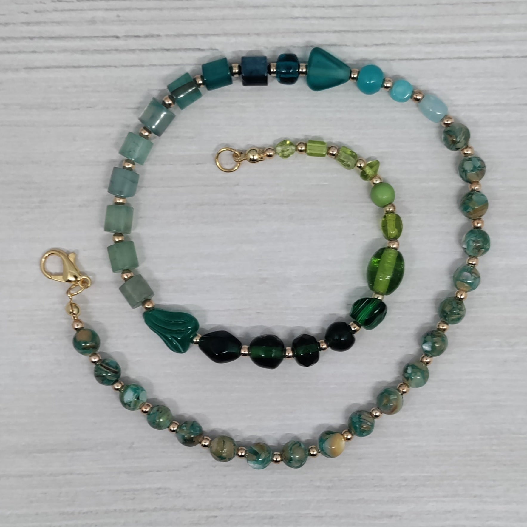 Set of beaded necklaces on a textured white surface