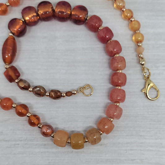 Beaded necklace and bracelet set on a light gray background
