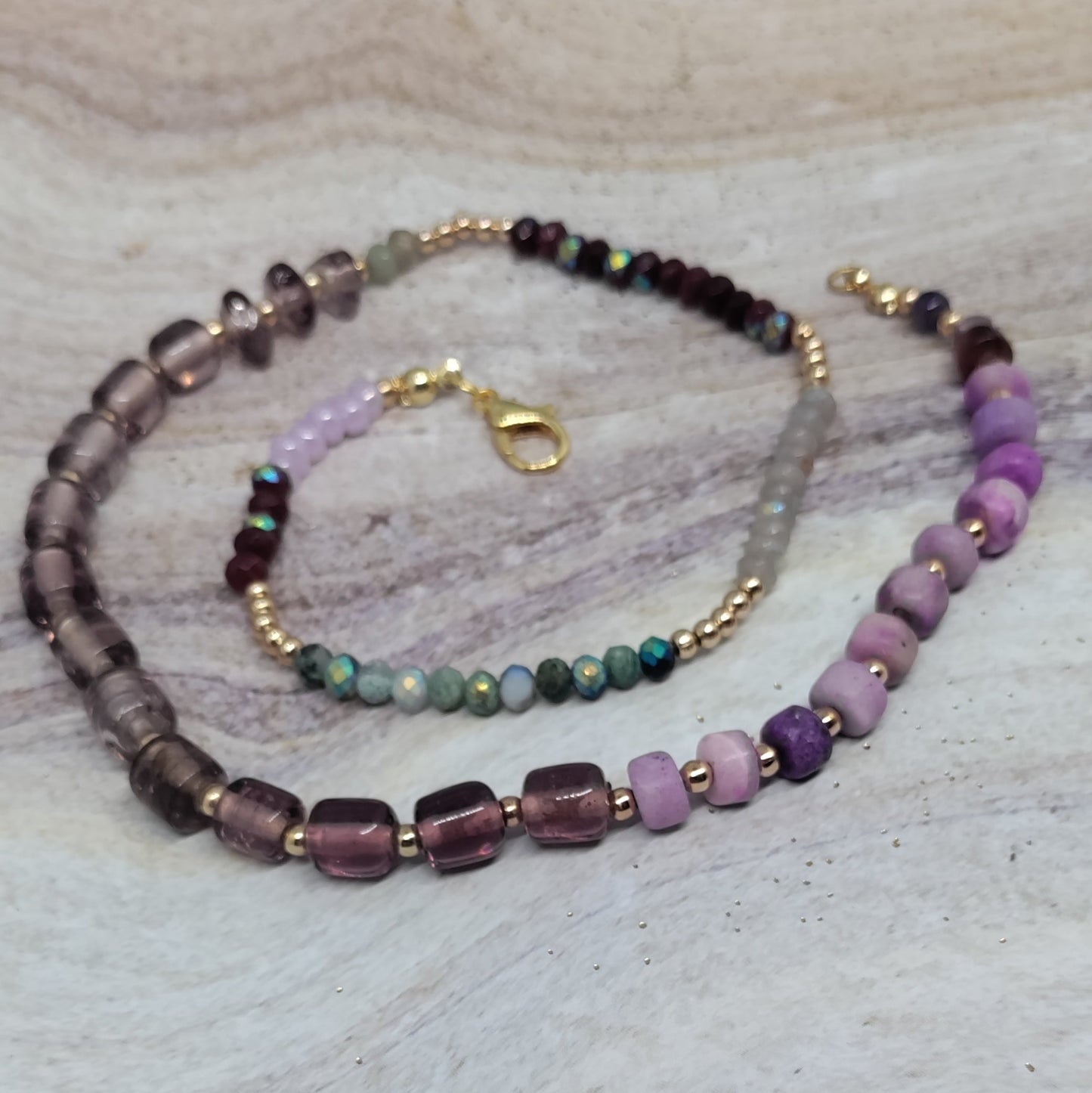 Beaded necklace and bracelet set on a light stone surface