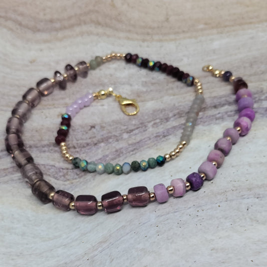 Beaded necklace and bracelet set on a light stone surface