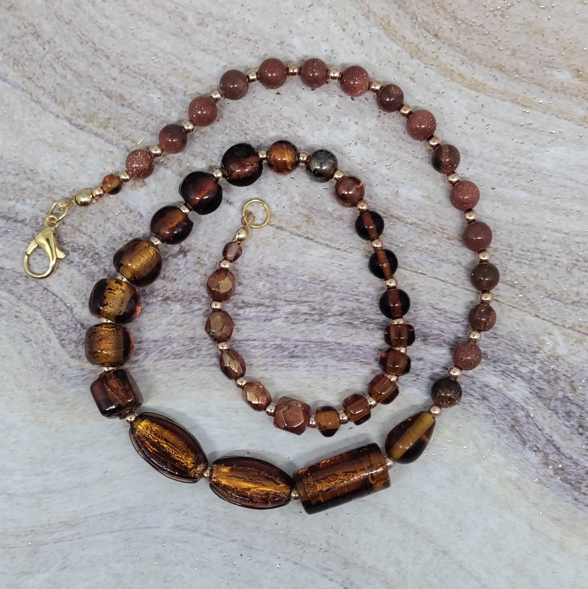 Beaded necklace and bracelet set on a textured surface