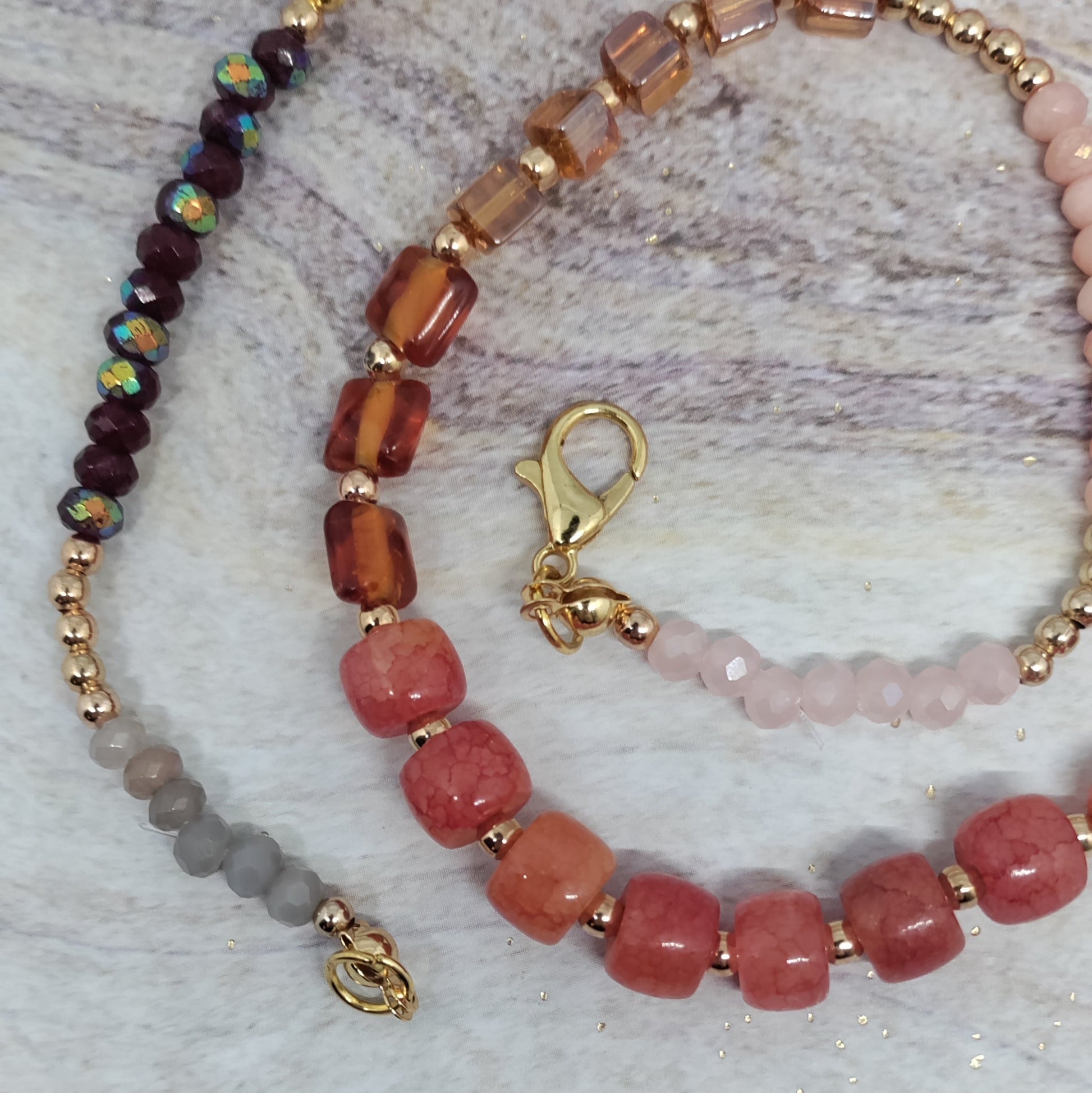 Beaded necklace with pink and brown beads on a textured surface