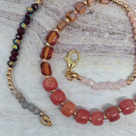 Beaded necklace with pink and brown beads on a textured surface