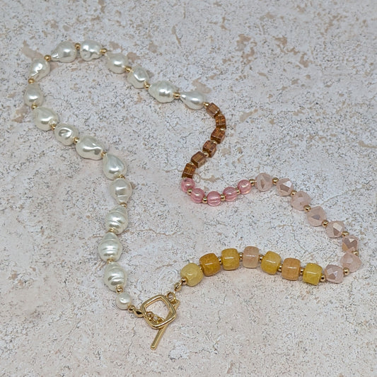 Beaded necklace with a gold clasp on a textured surface