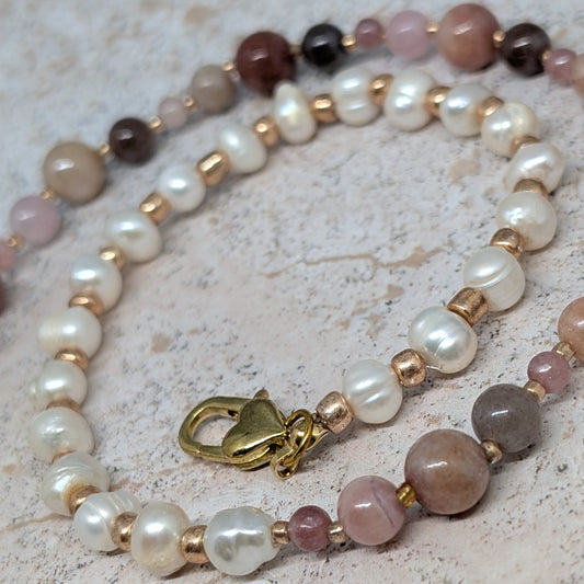 Necklace with pearls and multicolored beads on a textured surface