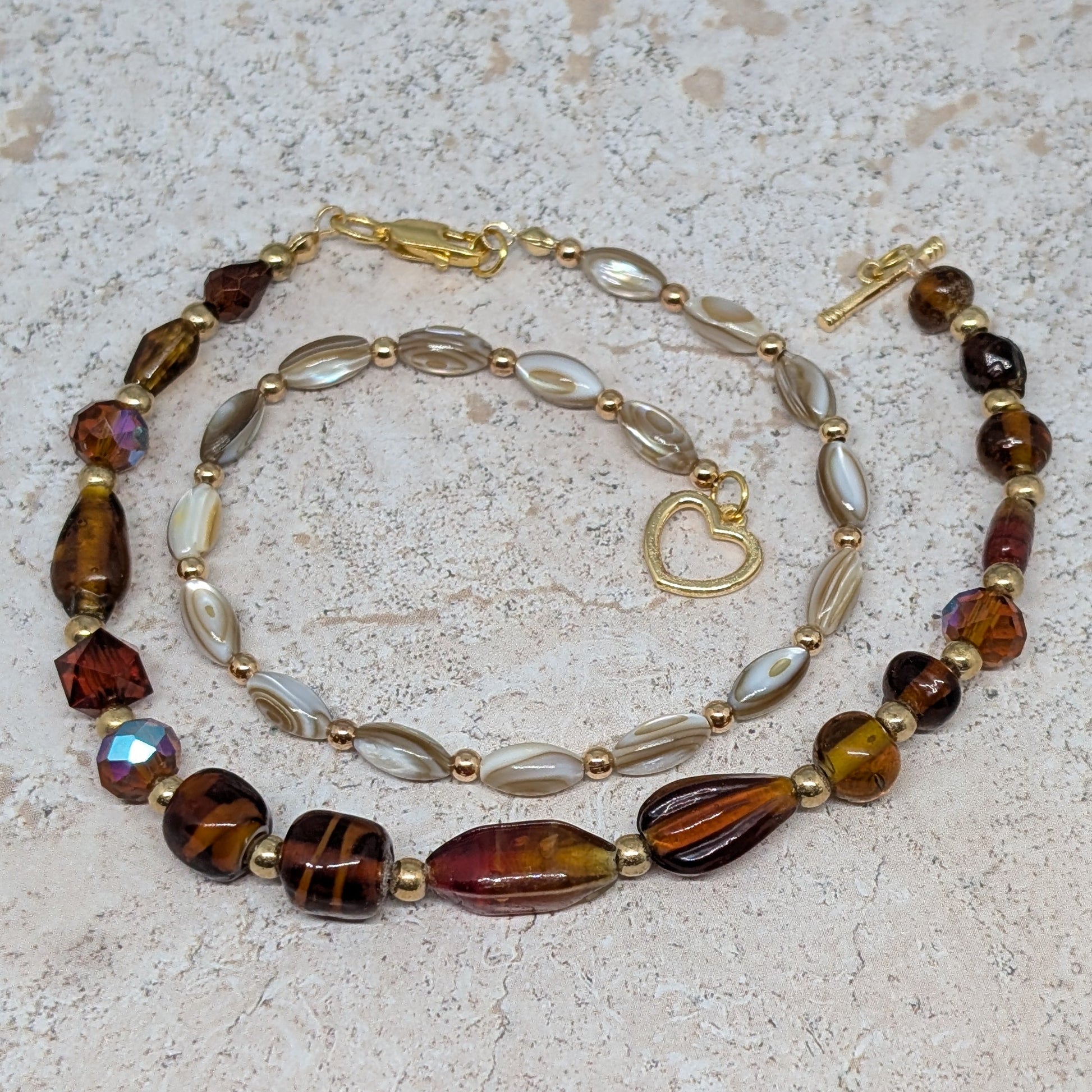 Beaded necklace with brown and gold beads on a textured surface