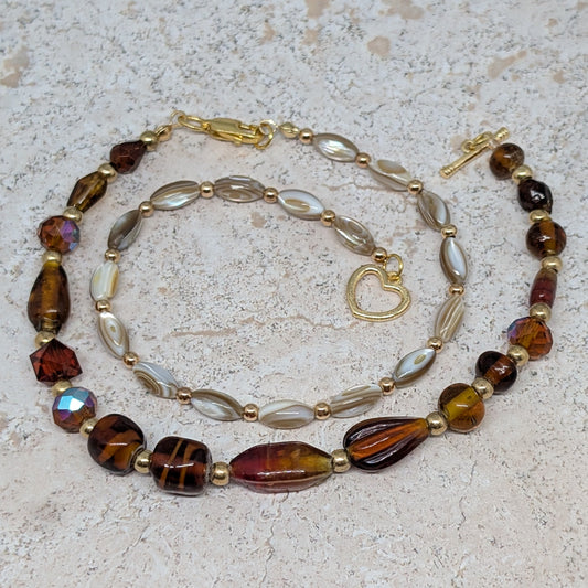 Beaded necklace with brown and gold beads on a textured surface
