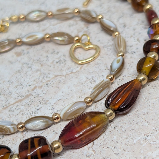 Beaded necklace with gold accents on a textured surface