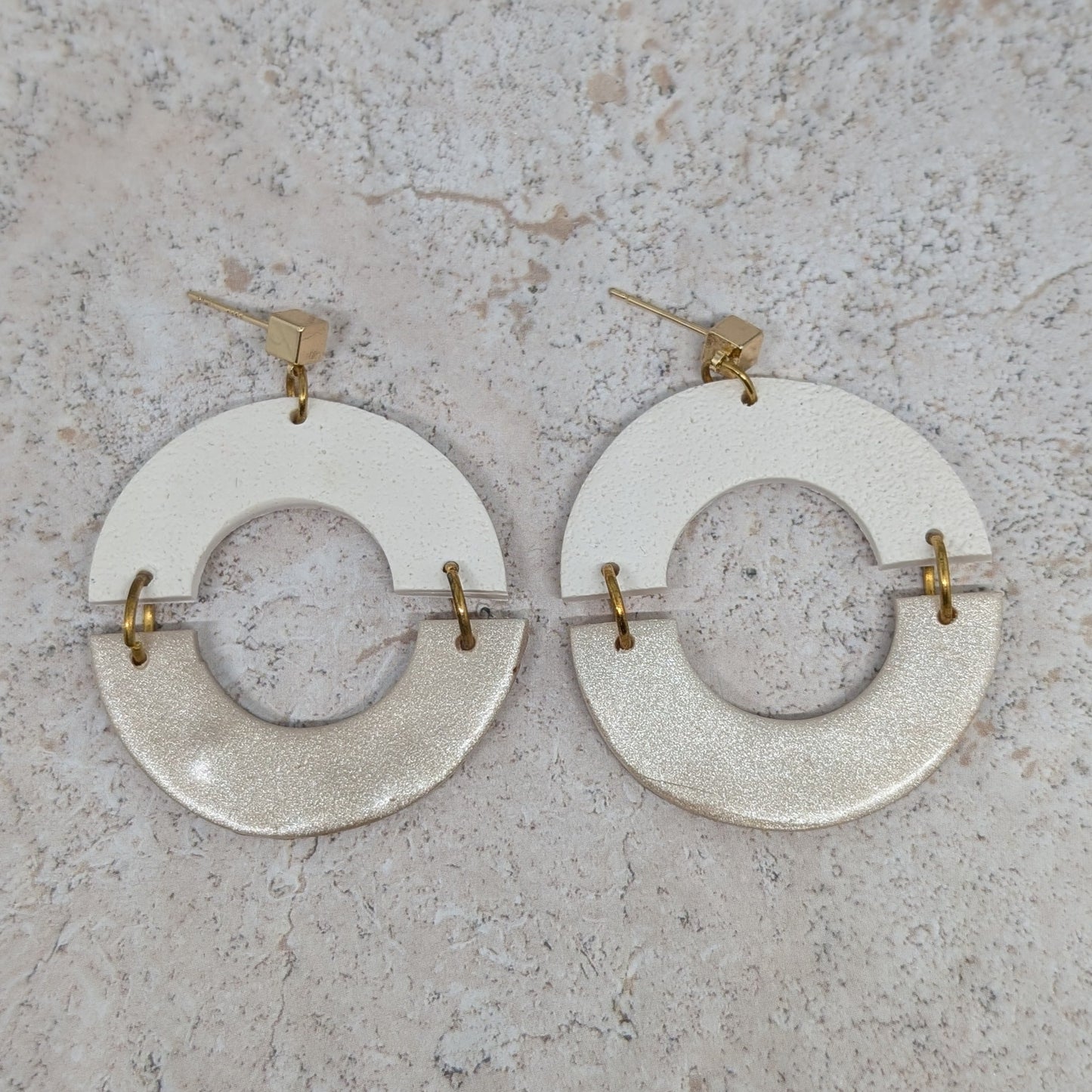 Pair of circular earrings on a textured surface